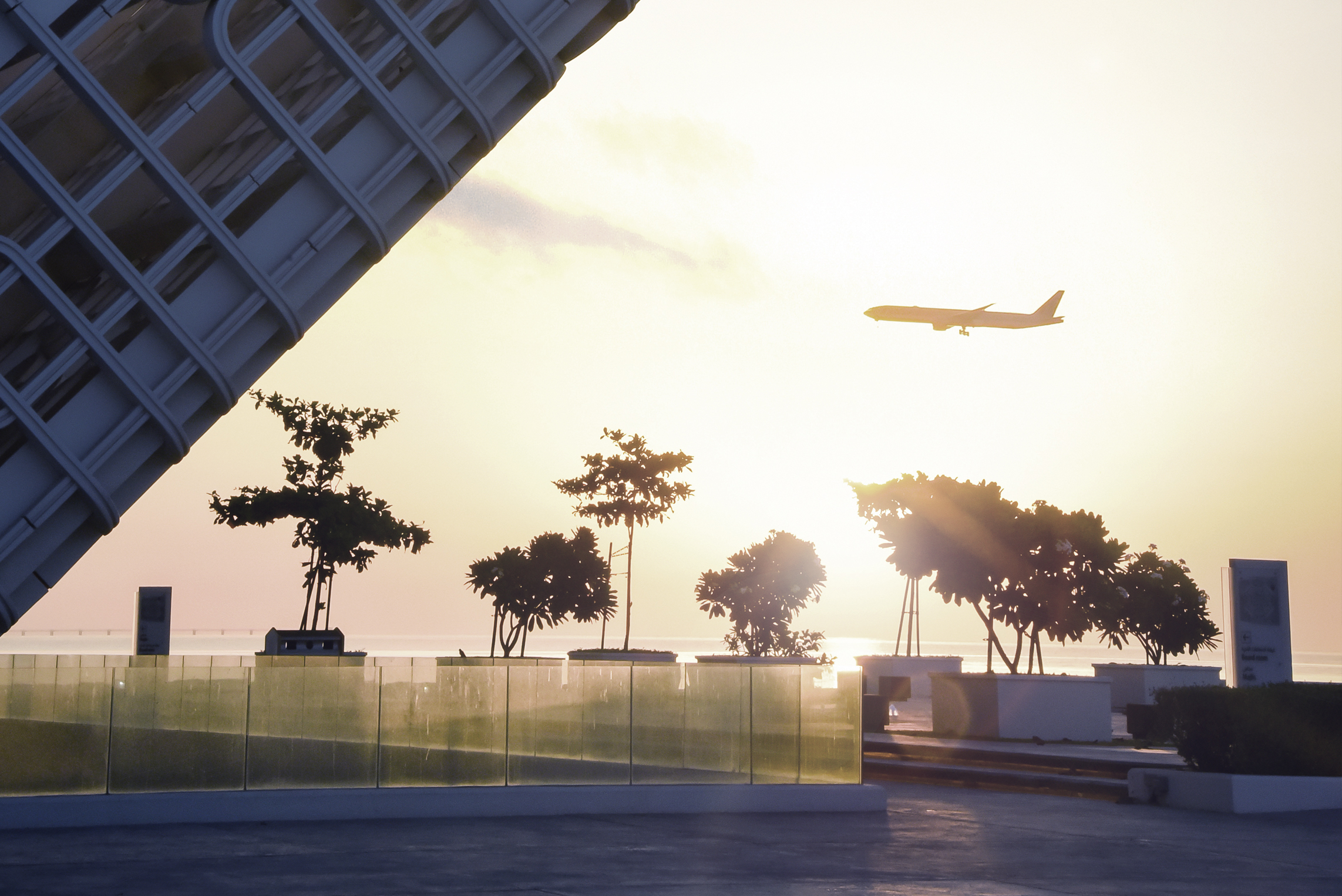 Large amount of air cargo, neatly packaged sitting on a runway, with airplane in background